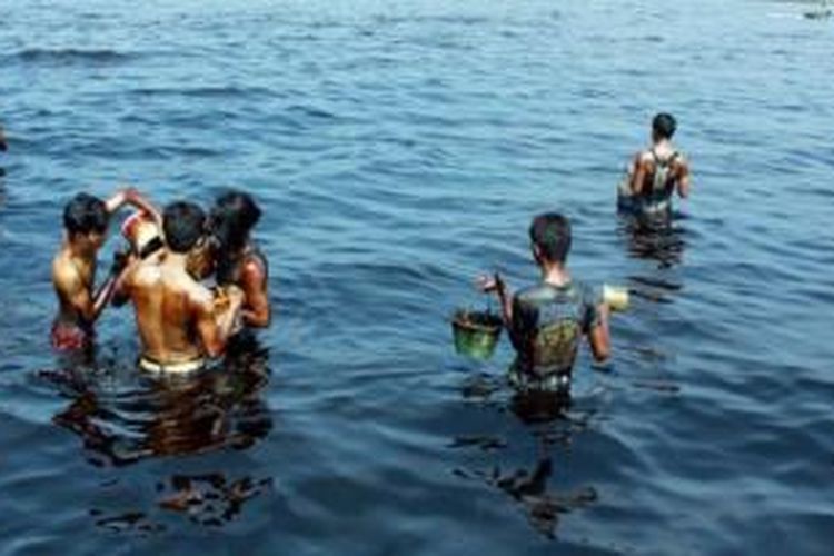 Warga dan nelayan, Senin (25/5) mengumpulkan ceceran minyak mentah yang mencemari kawasan wisata Pantai Teluk Penyu di Kabupaten Cilacap, Jawa Tengah. Ceceran minyak berasal dari kebocoran pipa fasilitas bongkar muat minyak mentah (Single Point Mooring) milik PT Pertamina Refinery Unit IV Cilacap yang rusak pada Rabu (20/5) malam. Sebanyak 14.000 liter minyak keluar dari pipa, namun sebagian besar telah disedot dan dilokalisasi oleh Pertamina.