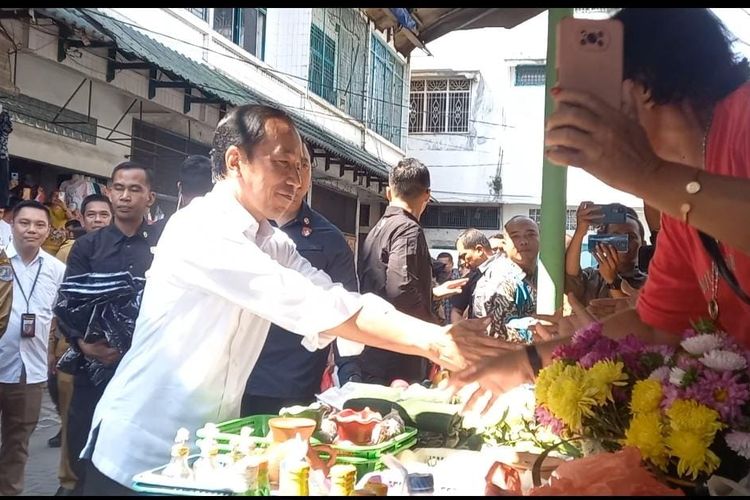 Jokowi bersalaman dengan pedagang saat meninjau Pasar Brahrang, di Kota Binjai, Jum'at (25/8/2023). 