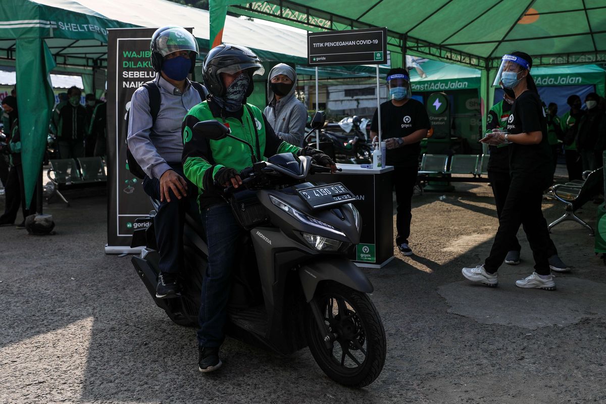 Pengemudi ojek online dengan penumpangnya melintas di Kawasan Stasiun Sudirman, Jakarta Pusat, Senin (8/6/2020). Pemerintah Provinsi DKI Jakarta mengizinkan pengemudi ojek online beroperasi untuk mengangkut penumpang selama PSBB transisi dengan menerapkan protokol kesehatan.