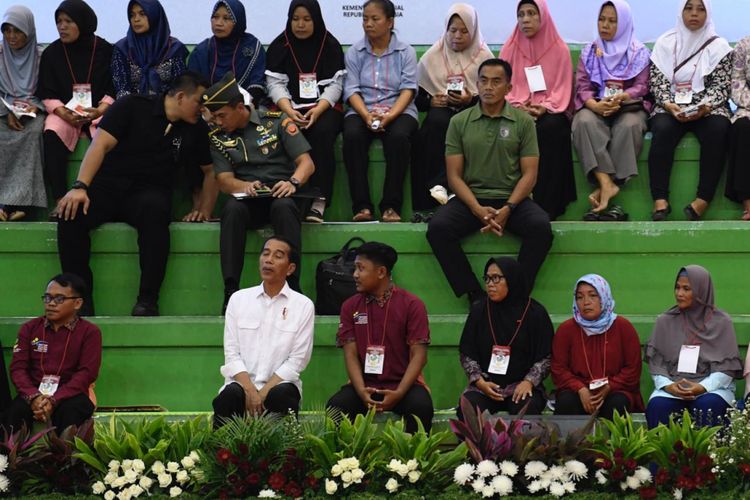 Presiden Joko Widodo tampak berbincang dengan salah satu penerima PKH yang duduk di sebelahnya di GOR Ciracas, Jakarta Timur, Kamis (10/1/2019).
