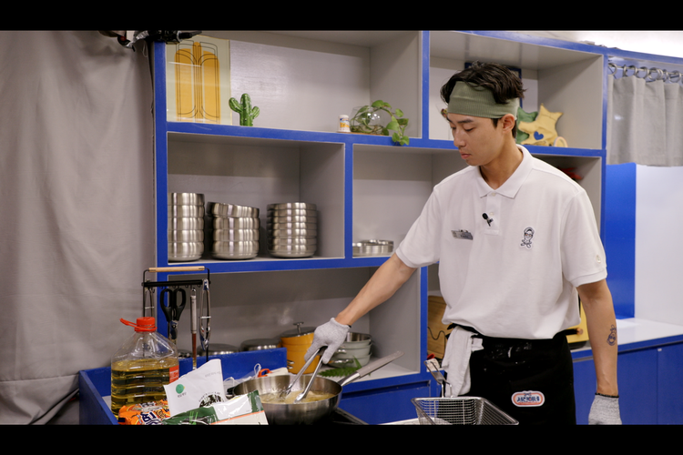 Aktor Park Seo Joon sedang menyiapkan hidangan dalam reality show Jinny's Kitchen.