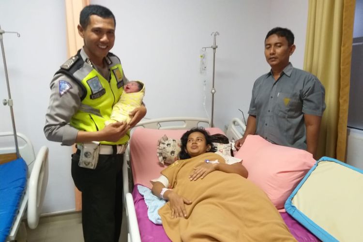 Personel Satlantas Polresta Pekanbaru, Bripka M Syafrial menggendong bayi yang baru lahir dari ibu yang ditolongnya saat terjebak macet menuju rumah sakit di Pekanbaru, Riau, Sabtu (25/5/2019). 