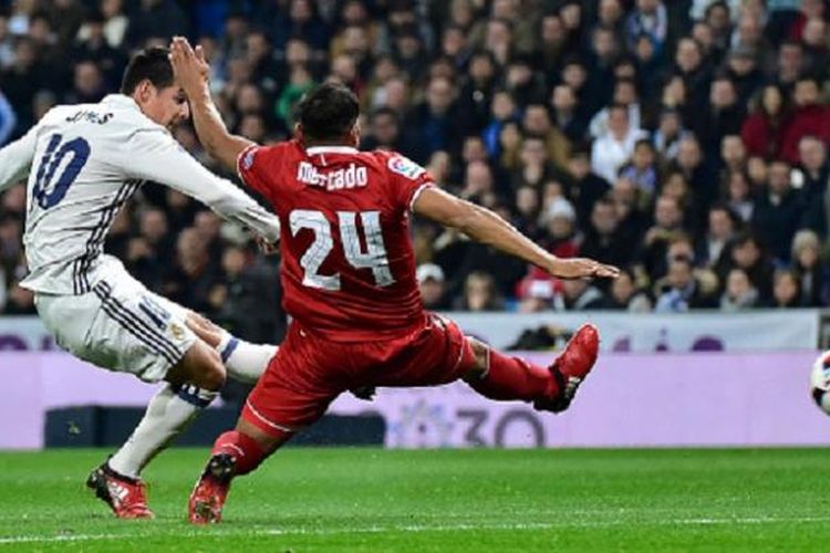 James Rodriguez menembak bola seusai melewati hadangan bek Sevilla, Gabriel Mercado, pada pertandingan Copa del Rey di Santiago Bernabeu, Rabu (4/1/2017).