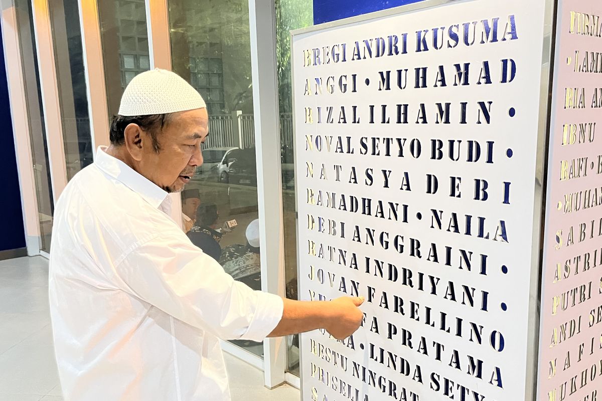 Nuri Hidayat saat menunjukkan nama-nama korban Tragedi Kanjuruhan yang diabadikan di area Gate 13 Stadion Kanjuruhan.