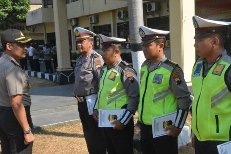 Empat anggota Satlantas Polresta Solo mendapat penghargaan dari Kapolresta Solo, Kombes Pol Ribut Hari Wibowo (kiri) usai apel pagi di Mapolresta Solo, Senin (17/9/2018) pagi. 
