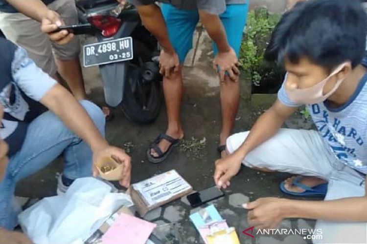 Petugas kepolisian ketika memeriksa paket berisi amplop ganja dan botol cairan yang masih ada bentuk butiran kristal di Lembar, Lombok Barat, NTB, Jumat (6/11/2020).