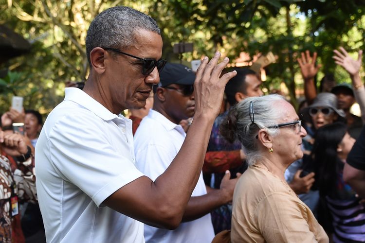 Mantan presiden AS Barack Obama memberi isyarat saat mengunjungi Kuil Tirtha Empul di Desa Tampaksiring, Gianyar, Bali, Selasa (27/6/2017). Obama berlibur ke Indonesia selama 10 hari dan berencana mengunjungi sejumlah kota, yaitu Bali, Yogyakarta, dan Jakarta.