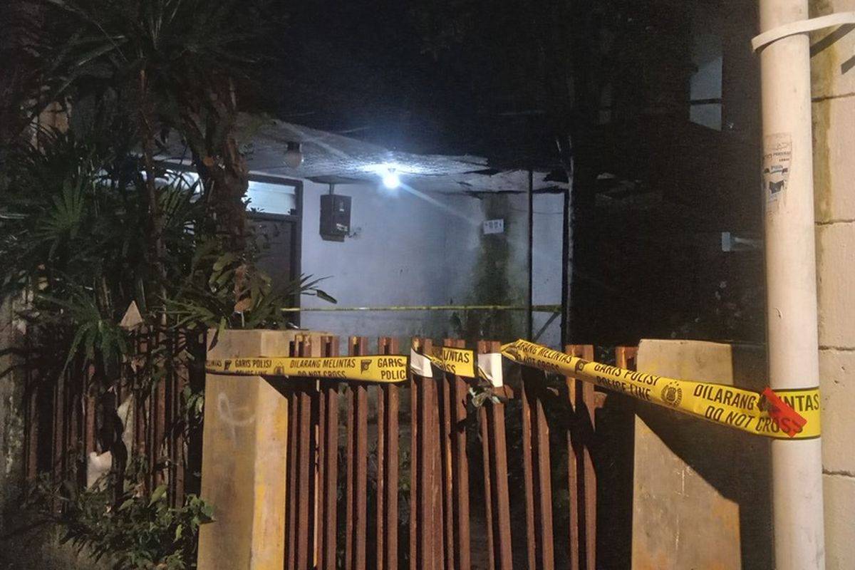 lokasi rumah penemuan jasad lansia yang terkubur dalam ruang kamar telah dipasangi garis kuning polisi, Selasa (29/4/2025)