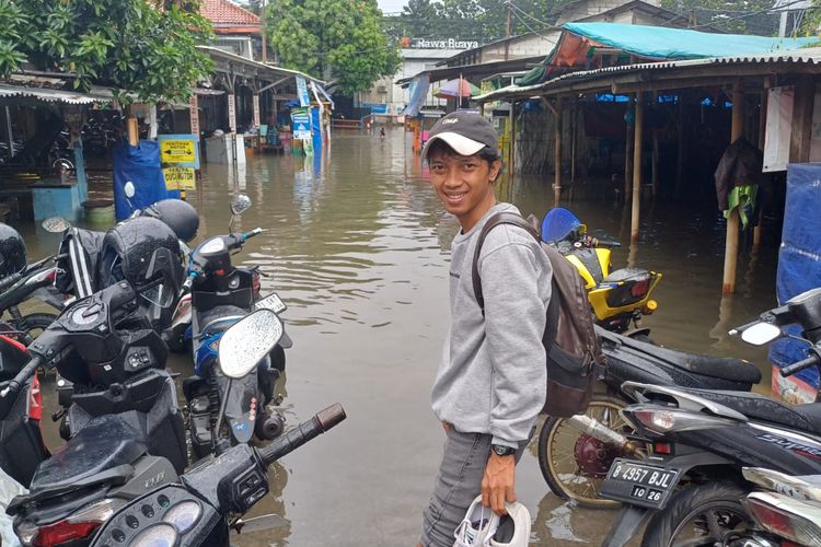 Riski terpaksa lintasi banjir di depan Stasiun Rawa Buaya, Cengkareng, Jakarta Barat. 