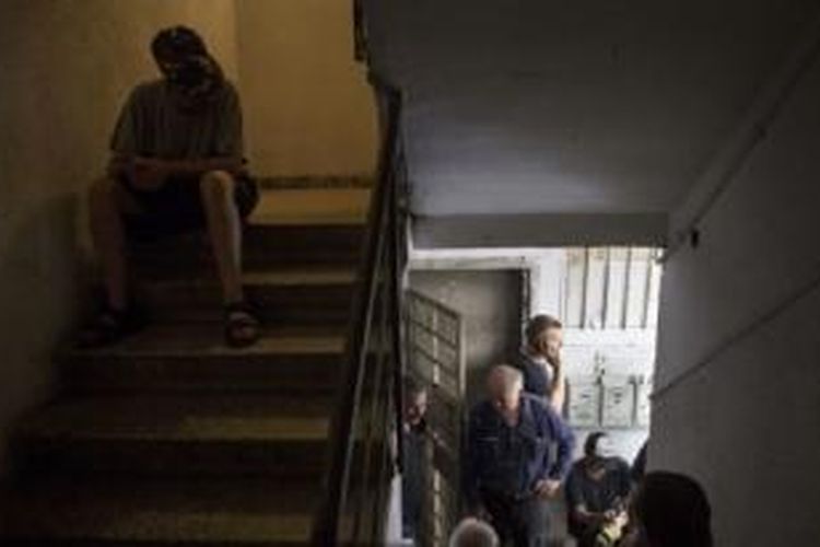 Warga Israel berlindung di bunker rumahnya setelah alarm peringatan roket Hamas berbunyi di Tel Aviv, Senin (21/7/2014).