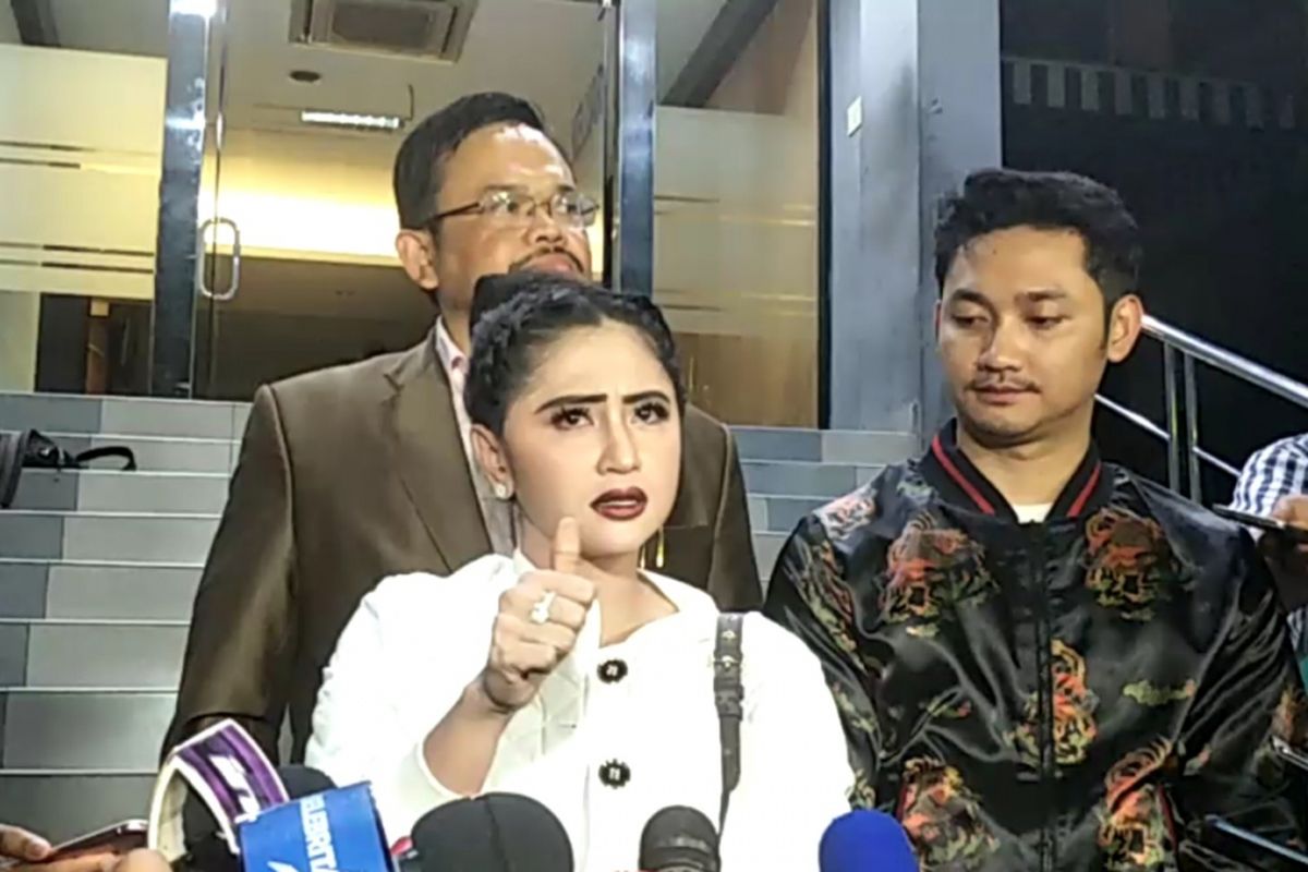 Dewi Perssik (kiri) mendampingi suaminya Angga Wijara (kanan) melaporkan seorang petugas Transjakarta ke Sentra Pengaduan Kepolisian Terpadu (SPKT) Polda Metro Jaya, Senin (4/12/2017) malam.