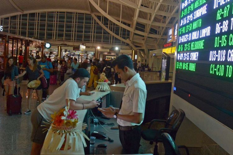 Calon penumpang menunggu jadwal penerbangan di Bandara Ngurah Rai Bali, Sabtu (25/11/2017) malam. Sebanyak 17 jadwal penerbangan internasional dari dan menuju Bali dibatalkan karena dampak erupsi Gunung Agung. 
