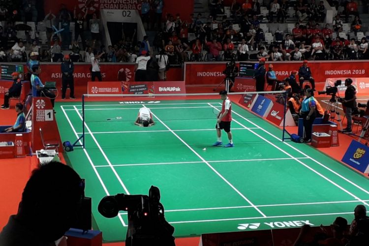 Atlet para bulu tangkis Indonesia, Dheva Anrimusthi, sujud syukur setelah berhasil lolos ke final cabang olahraga nomor tunggal putra SU5. Di semifinal, Ukun berhasil mengandaskan perlawanan atlet Malaysia, Liek Hou Cheah, dengan skor 18-21, 21-14 dan 21-16 dalam laga yang digelar di Istora, Senayan, Jakarta, Jumat (12/10/2018).