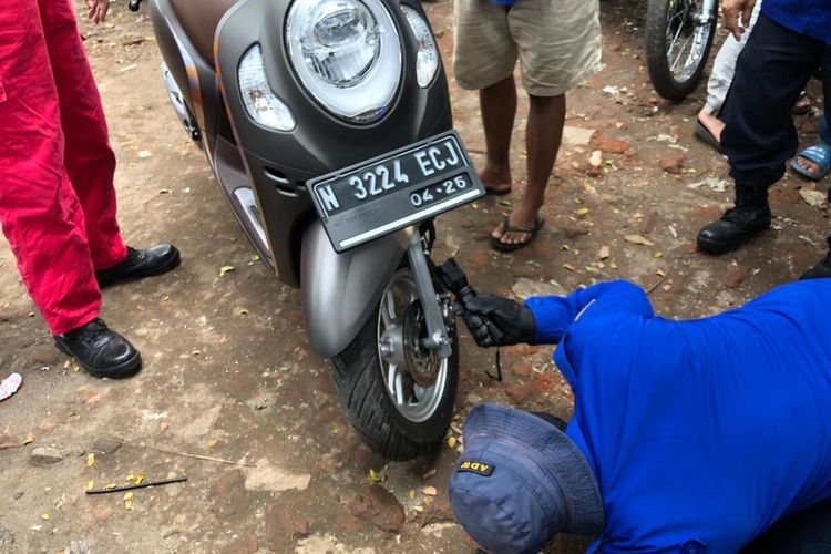 Petugas UPT Pemadam Kebakaran Kota Malang saat mengevakuasi ular dari dalam motor warga, Selasa (22/6/2021).