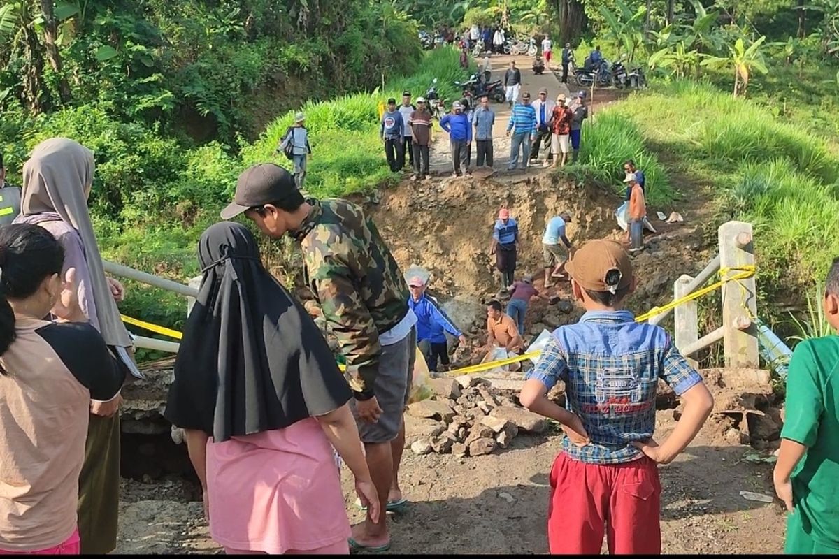 Sejumlah warga di Desa Jabranti Kecamatan Karangkencana Kabupaten Kuningan tidak dapat melintasi jembatan Cirombeng, yang roboh pada Sabtu petang (8/4/2023). Jembatan ini mengakibatkan 2.200 warga terisolasi karena merupakan akses utama dan satu satunya yang dapat dilintasi warga.