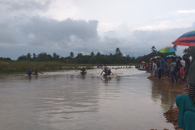 Ratusan warga antusias menyaksikan pacu sampan yang digelar di tengah banjir di Desa Sontang, Kecamatan Bonai Darussalam, Kabupaten Rohul, Riau, Minggu (1/12/2019).