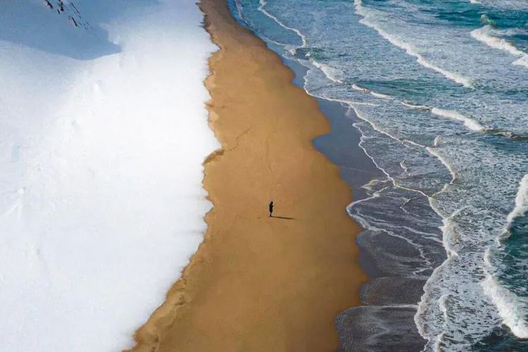 Sebuah pantai di Jepang dengan pemandangan unik dengan salju, pasir, dan laut yang menyatu di lokasi yang sama viral di dunia maya. Foto ini diambil di pantai barat Jepang di San'in Kaigan GeoPark oleh fotografer Hisa.