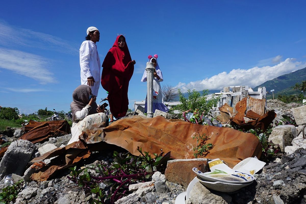 Warga berdoa di tempat hilangnya anggota keluarga mereka di lokasi bekas terdampak likuefaksi di Kelurahan Balaroa, Palu, Sulawesi Tengah, Rabu (5/6/2019). Usai melaksanakan shalat Idul Fitri, umat muslim korban bencana mendatangi lokasi permukiman penduduk yang hancur akibat gempa dan likuefaksi tersebut untuk mengenang dan mendoakan keluarga mereka yang meninggal dunia atau dinyatakan hilang dalam peristiwa tersebut. ANTARA FOTO/Mohamad Hamzah/hp.                             