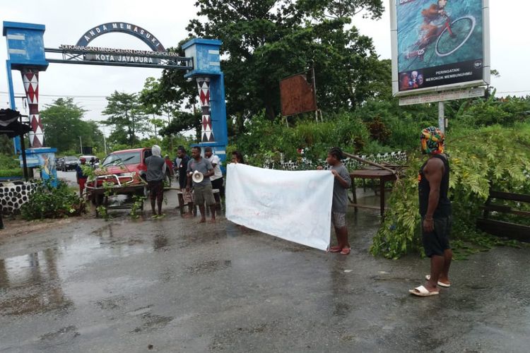 Warga saat memblokade jalan tras Kota Jayapura - Kabupaten Keerom. Warga kesal setiap kali hujan wilayah mereka terendam banjir akibat luapan air sungai, Kamis (27/12/2018).