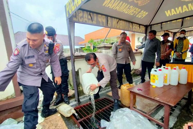 Ribuan liter minuman keras jenis sopi dimusnahkan dengan cara ditumpah ke dalam selokan di depan kantor Polresta Pulau Ambon, Kamis (21/7/2022)