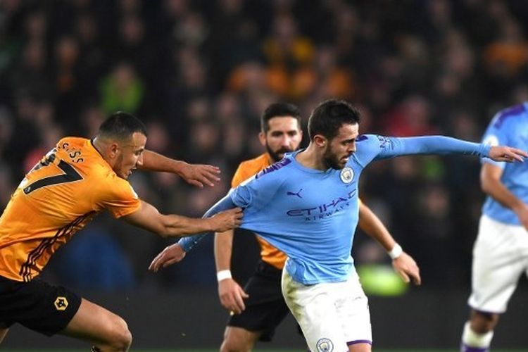 Bernardo Silva saat mencoba melewati Romain Saiss dari Wolverhampton Wanderers selama pertandingan Liga Premier antara Wolverhampton Wanderers dan Manchester City di Molineux.