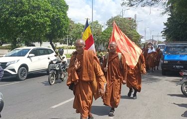 Salah seorang biksu yang memberi salam kepada warga saat mereka melintas di Jalan Teuku Umar, Telaga Asih, Cikarang Barat, Kabupaten Bekasi, Jumat (12/5/2023). Adapun tujuan akhir dari perjalanan biksu itu adalah Candi Borobudur, Magelang, Jawa Tengah untuk merayakan Hari Raya Waisak di tanggal 4 Juni mendatang.