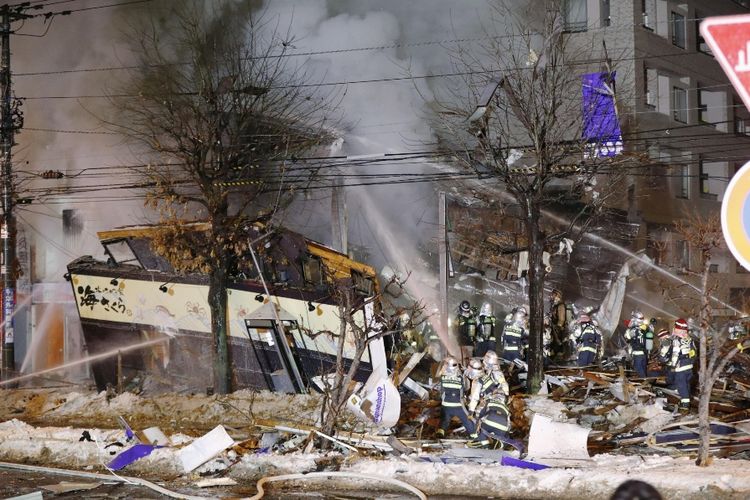 Petugas pemadam kebakaran bekerja memadam api menyusul ledakan yang terjadi di sebuah restoran di Sapporo, Minggu (16/12/2018) malam.