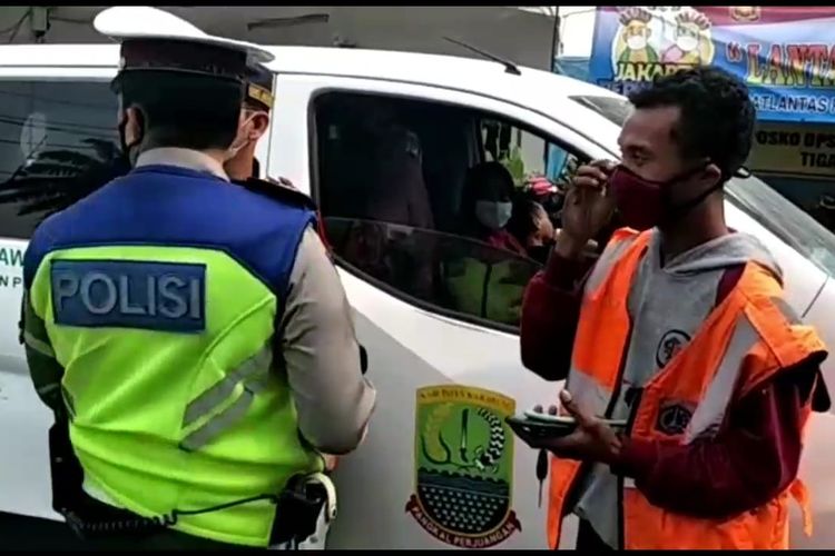 Seorang warga yang mengendarai mobil berplat merah dari Kabupaten Karawang diputarbalikkan oleh petugas saat hendak melintas pos check-point di Jalan Daan Mogot, Kalideres, Jakarta Barat, pada Senin (17/5/2021).