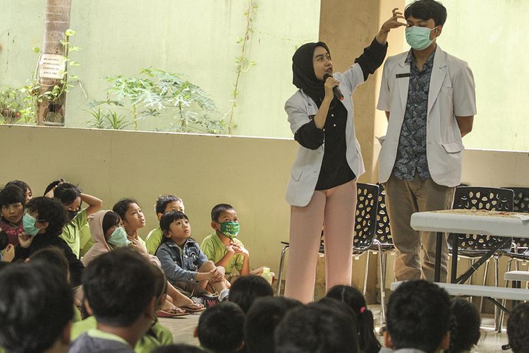 Petugas Puskesmas mempraktikan penggunaan masker kepada sejumlah siswa saat sosialisasi di Sekolah Tunas Global, Depok, Jawa Barat, Selasa (3/3/2020). Kegiatan tersebut sebagai upaya antisipasi Virus Corona pada usia dini dengan mengukur suhu tubuh saat memasuki sekolah dan mensosialisasi penggunaan masker yang benar saat sakit.