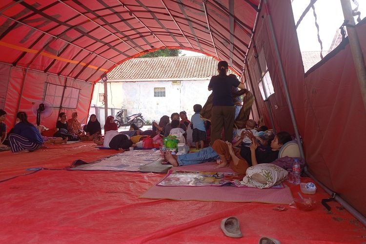 Warga terdampak gempa di Lingkungan Babakanhurip, Kotakaler Sumedang, Jabar mengungsi di tenda terbuka yang berlokasi di lapang lingkungan sekitar, Senin (1/1/2024). AAM AMINULLAH/KOMPAS.com