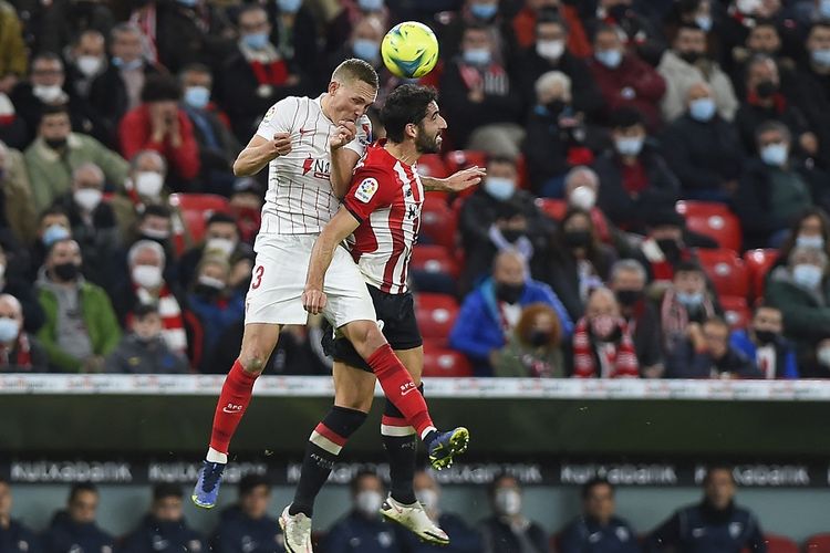 Bek Sevilla Ludwig Augustinsson (kiri) berebut bola dengan bek Athletic Bilbao Mikel Balenziaga pada La Liga Spanyol antara Athletic Bilbao vs Sevilla FC di Stadion San Mames di Bilbao pada 11 Desember 2021.