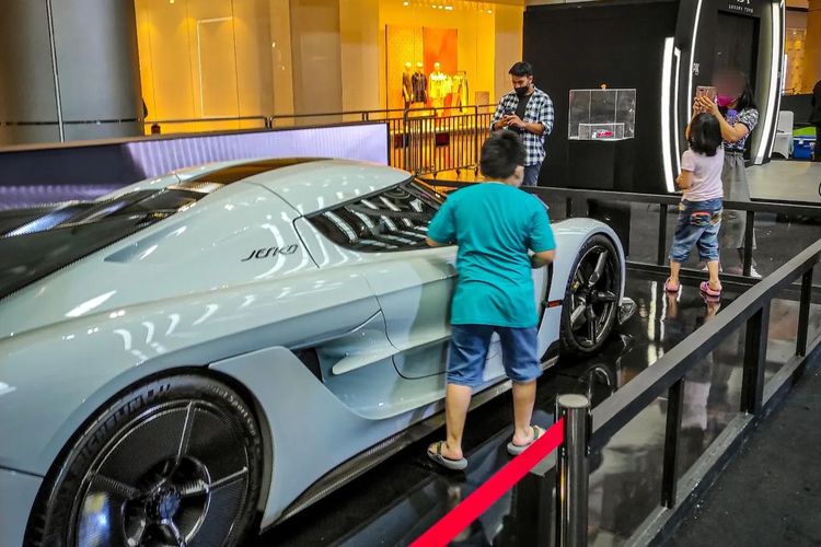 Pengunjung melewati pagar pembatas untuk berfoto dengan hypercar Koenigsegg Jesko yang dipamerkan di TDA Luxury Autoshow