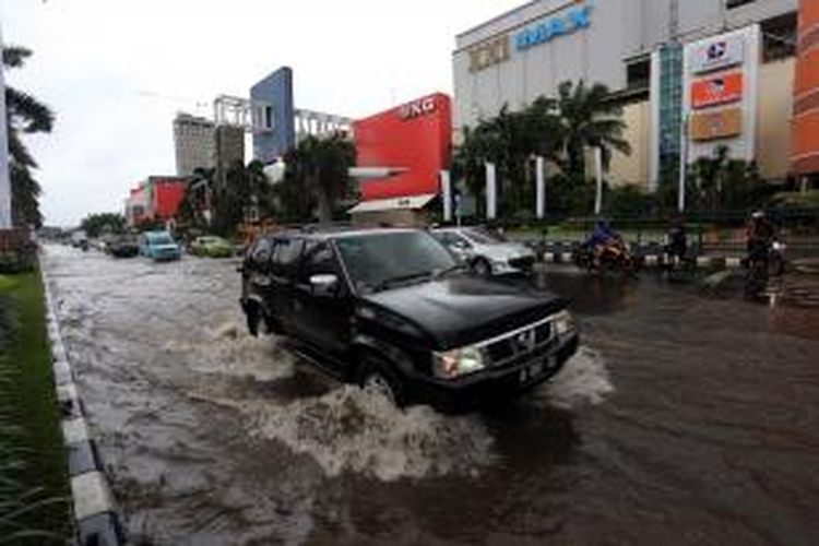 Pengendara melintasi genangan di Jalan boulevard, Kelapa Gading Jakarta Utara. Hujan lebat mengguyur Jakarta sejak pagi, membuat sejumlah jalanan Ibukota tergenang.