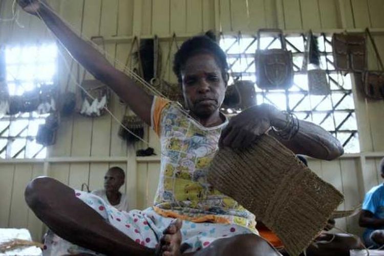 Warga menyelesaikan pembuatan noken (tas dari Papua) dari tali sagu di Sanggar Kelompok Gescu Cepes, Kampung Jasiw, Distrik Atsy, Kabupaten Asmat, Papua, Minggu (18/8/2013). Hasil kerajinan anyaman khas Asmat itu dijual Rp 500.000 per tas.  