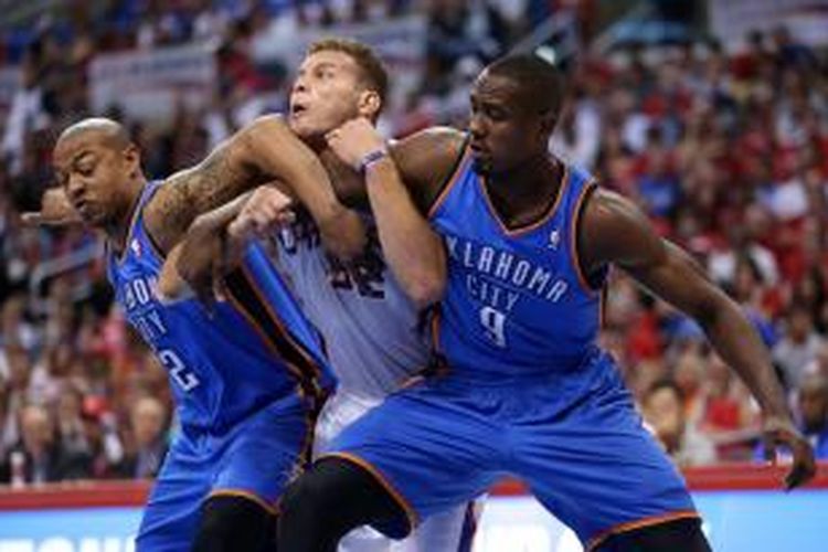 Pebasket Los Angeles Clippers, Blake Griffin (tengah) bersaing dengan dua pemain Oklahima City Thunder, Serge Ibaka (kanan) dan Caron Butler pada laga laga keempat semifinal Wilayah Barat di Satples Center, Minggu (11/5/2014). Clippers mennag 101-99.