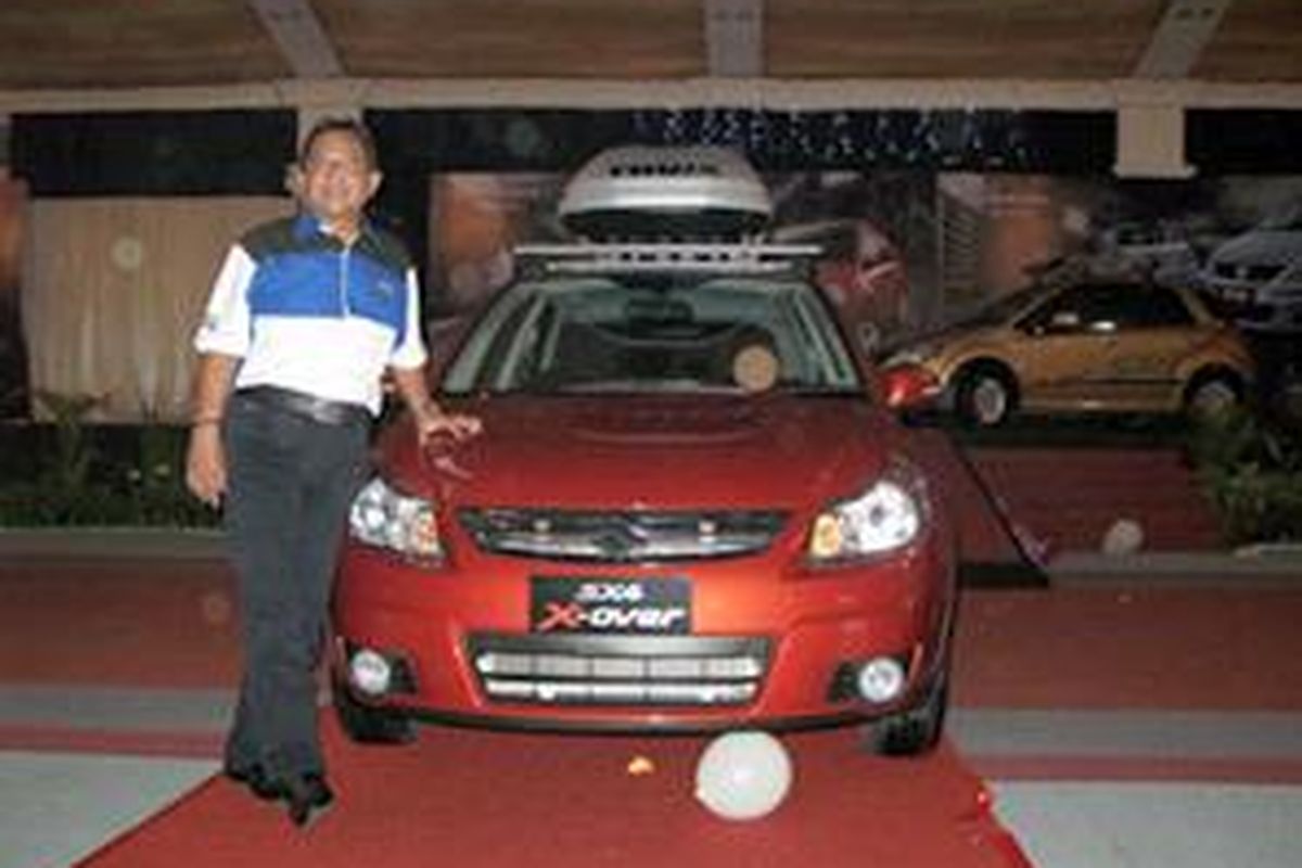 Direktur Utama INDO Mobil Niaga International (IMNI) Subronto Laras berpose di depan sedan hatchbach SX4 CrossOver  yang diproduksi di perakitan mobil Suzuki, Bekasi, Jawa Barat. 