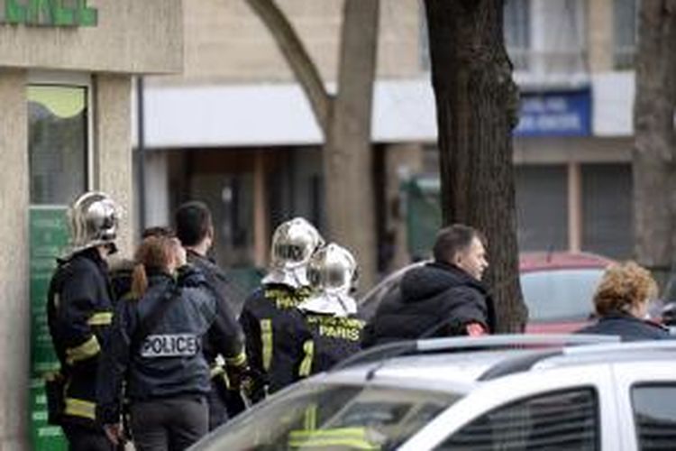 Petugas polisi Perancis bersiap di luar sebuah toko makanan Yahudi di Paris yang diduduki seorang pria bersenjata, Jumat (9/1/2015).