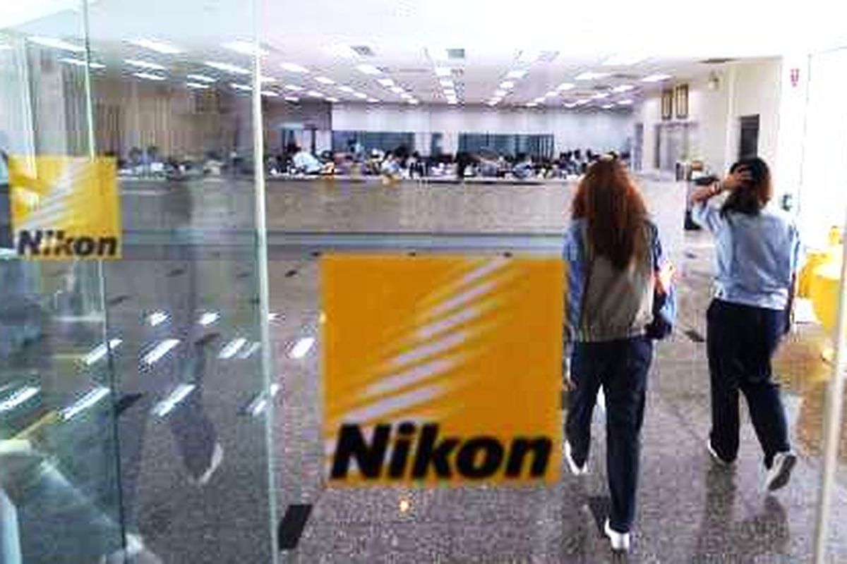 Karyawan berjalan di lobi pabrik Nikon Thailand Co.Ltd yang berada di kawasan industri Rojana, Ayutthaya, Thailand, Jumat (10/10/2014). Nikon Thailand mulai beroperasi pada 1990, dan saat ini mempekerjakan 7.404 karyawan.