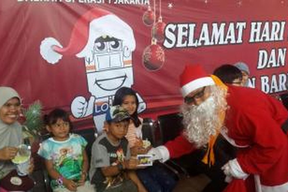 Sinterklas dari PT KCJ membagi-bagikan hadiah pada anak-anak di Stasiun Kota, Jakarta Barat, Jumat (25/12/2015).