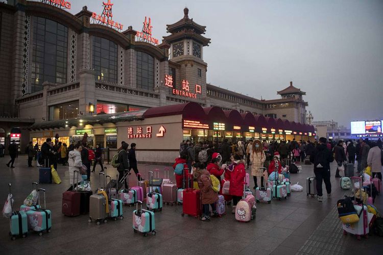 Orang-orang menunggu di luar Stasiun Kereta Api Beijing, China, sebelum naik kereta menuju kampung halaman mereka, Selasa (29/1/2019). Jutaan penduduk China telah memulai mudik menjelang Tahun Baru Imlek, yang menjadi migrasi manusia tahunan terbesar di dunia.