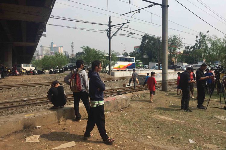 Sejumlah warga khususnya anak-anak terlihat berlarian melintasi rel kereta yang berada di sekitar Kali Grogol, Jakarta Barat. Adapun warga berlarian untuk melihat kemunculan buaya di Kali Grogol. Warga berlarian melintasi rel kereta tanpa memperdulikan tanda bahwa kereta akan melintas, Jumat (29/6/2018).
