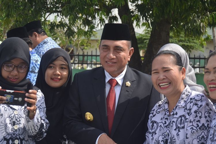 Gubernur Sumatera Utara, edy Rahmayadi berfoto bersama dengan guru-guru usai berziarah dan peringatan Hari Guru Nasional di Taman Makam Pahlawan, Medan, Senin (25/11/2019). Dalam kesempatan tersebut, Edy mengatakan bahwa gaji guru sudah dinaikkan dari Rp 40.000/jam menjadi Rp 90.000/jam. Sementara Kadisdik Sumut, Arsyad Lubis menyebut bahwa guru honorer masih belum sejahtera.