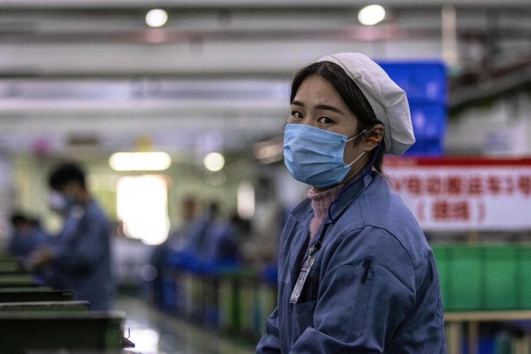 Seorang wanita yang mengenakan masker pelindung bekerja di pabrik Galanz di Foshan, Cina, 18 Februari 2020. Sementara Airbus, General Motors, Toyota, Foxconn dan banyak lainnya mulai berproduksi mengikuti aturan baru yang dikeluarkan oleh otoritas lokal. EPA-EFE/ALEX PLAVEVSKI
