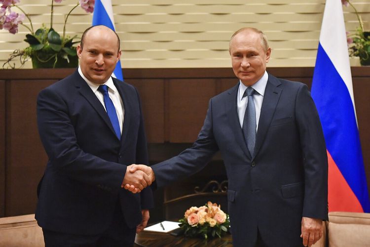 Presiden Rusia Vladimir Putin, kanan, dan Perdana Menteri Israel Naftali Bennett berjabat tangan selama pertemuan mereka di Sochi, Rusia, Jumat, 22 Oktober 2021. 
