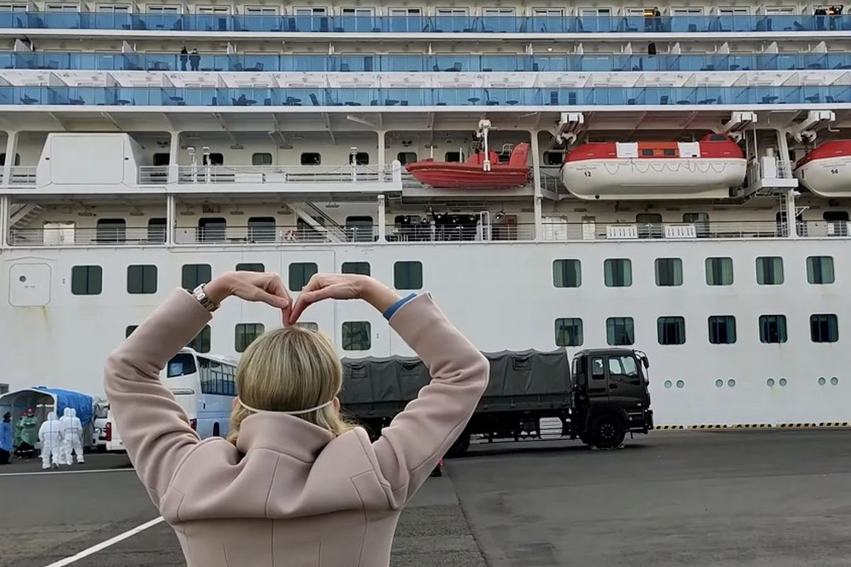 Presiden Princess Cruises Jan Swartz membentuk hati dengan kedua tangannya ke arah kapal pesiar Diamond Princess, saat penumpang turun dari kapal setelah karantina, akibat penularan virus korona baru (COVID-19) di dermaga di Yokohama, Jepang, Kamis (20/2/2020), dalam gambar yang didapatkan dari video di media sosial. ANTARA FOTO/Princess Cruises via REUTERS/aww/cfo