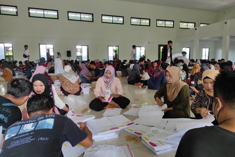Ratusan orang berjubel di Gedung Ikatan Persaudaraan Haji Indonesia (IPHI) Kabupaten Demak, melakukan sortir dan melipat surat suara DPR RI, Kamis (4/1/2024) (KOMPAS.COM/NUR ZAIDI) 