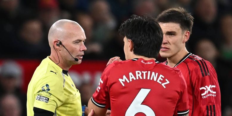 Wasit Paul Tierney berbicara dengan Lisandro Martinez yang menarik rambut striker Leeds United Dominic Calvert-Lewin dan mendapatkan kartu merah dalam pertandingan sepak bola Liga Inggris antara Manchester United vs Leeds United di Old Trafford di Manchester, barat laut Inggris, pada 13 April 2026. (Foto oleh Paul ELLIS / AFP) 