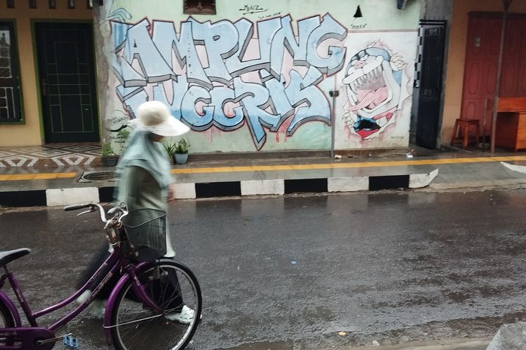 Seorang pelajar melintas di depan mural bertuliskan Kampung Inggris di kawasan Kampung Inggris, Kecamatan Pare, Kabupaten Kediri, Jawa Timur.