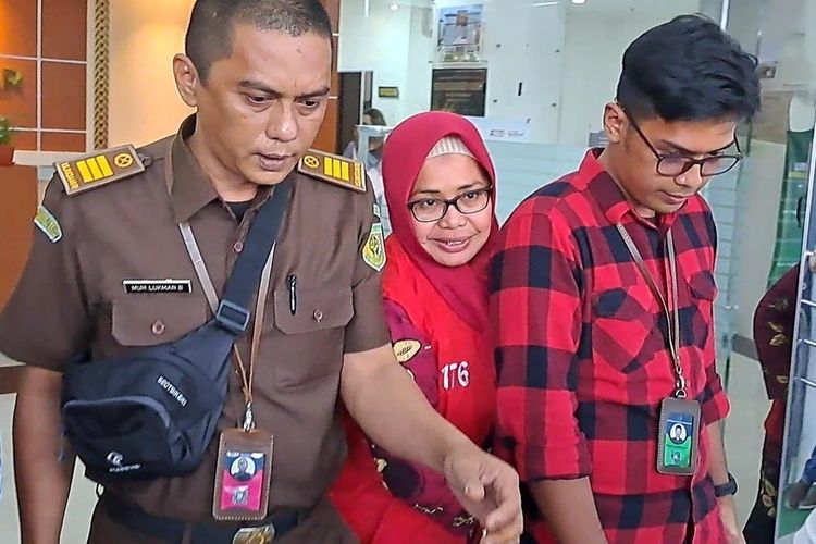 Kepala Dinas Perpustakaan Kota Makassar Tenri A. Palallo saat digiring ke mobil tahanan Kejari Makassar, Jumat (19/5/2023)