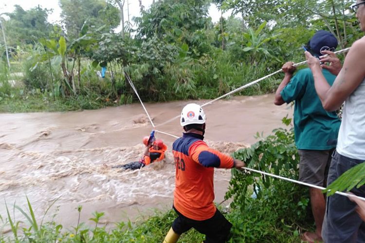 Personel BPBD Kabupaten Blitar mengevakuasi dua pemancing yang terjebak di tengah Sungai Lekso di Kecamatan Wlingi, Kabupaten Blitar, Jumat (8/4/2022) sore